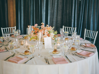 Elegant dining setup with floral centerpiece and soft lighting at a festive gathering in a serene...