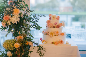 Elegant wedding cake adorned with fresh flowers at a lovely venue during a special celebration