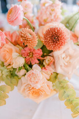 Colorful floral arrangement featuring roses, zinnias, and greenery for an elegant table setting at...