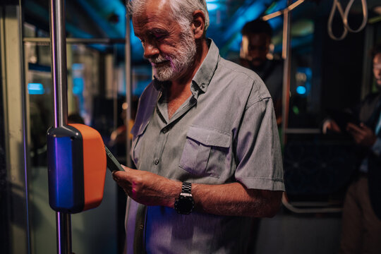 Senior man using smartphone to pay public transport fare - Powered by Adobe