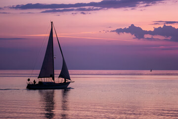 Fototapeta premium Sailboat Silhouette on Calm Sea with Soft Dusk Sky Gradient