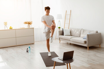 Online Training, Home Workout. Smiling Sporty Asian Guy Stretching Leg And Hamstring Muscles, Doing...