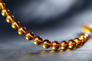 A close-up shot of a beautiful amber necklace on a dark background, showcasing the natural beauty and details of each bead