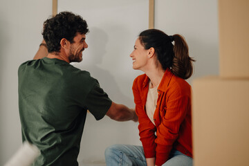 Couple decorating new home hanging a picture frame on wall