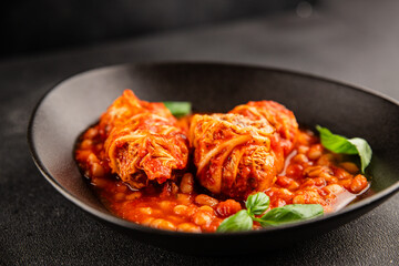 Stuffed cabbage tomato sauce with beans meat, cabbage, fresh delicious gourmet food background on the table rustic food top view copy space