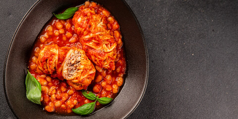 Stuffed cabbage tomato sauce with beans meat, cabbage, fresh delicious gourmet food background on the table rustic food top view copy space