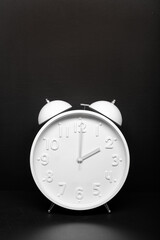 Daylight saving time concept. White Retro clock isolated on black background. Copy space
