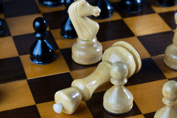 A close-up of a chessboard with wooden pieces.