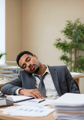 Young manager is sleeping at his desk during work time, feeling exhausted and unmotivated