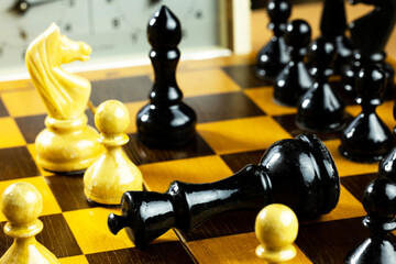 A close-up of a chessboard with black and white pieces. 