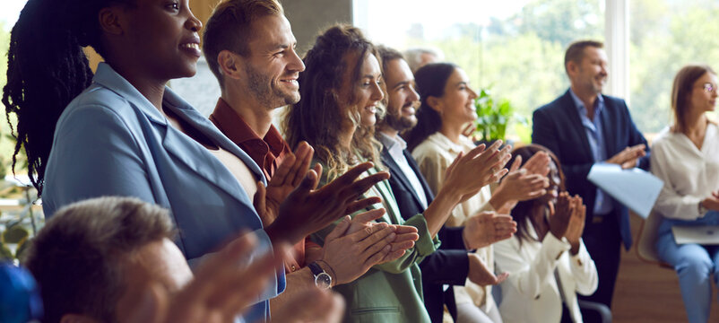 Diverse group of business people applauding during an office event or meeting. The crowd shows shared achievements and teamwork, transforming the office into a vibrant space of successful work.