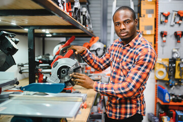 African american male buyer chooses a toolbox in a hardware store. A large selection of tools