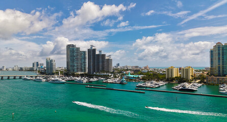 Naklejka premium Aerial view of luxury yachts in Miami marina. Scenic panorama of boats and skyscrapers in Miami marina. Cruise yacht sailing along the Miami coastline.