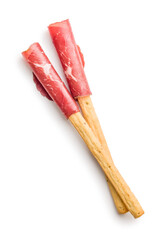 Slices of smoked bresaola and grissini sticks isolated on white background.