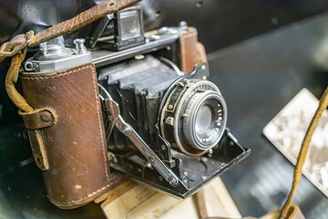 Vintage leather-cased antique camera on a flat surface, subdued lighting, muted earth tones,...