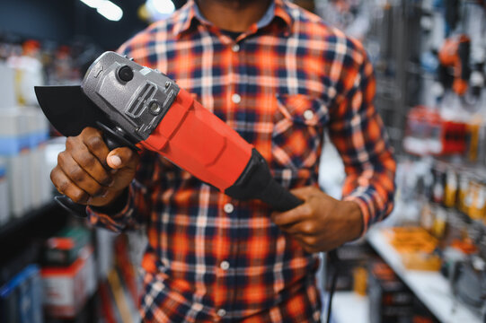 A african american man chooses a power tool in a hardware store