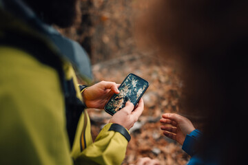 Hikers using smartphone gps to navigate in forest trail