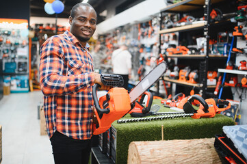 African american Man holds electric saw in tool store
