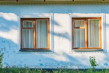 Old Central European building with two windows, one closed and one half-closed Balcony railing...