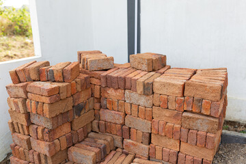 Stack of red clay bricks for construction
