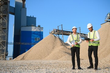 Two engineers at an industrial plant. Crushed stone production plant. Gravel