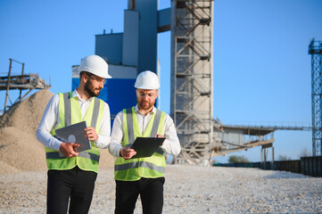 Two engineers at a stone crushing plant. The concept of quarrying.