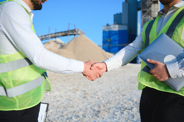 Two engineers or businessmen at an industrial plant. Plant for extraction and production of gravel