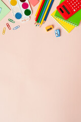 School backpack with stationery on colored background.