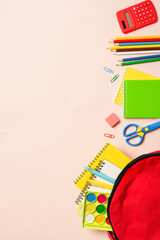 School backpack with stationery on colored background.