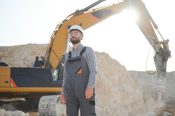 Extraction of stone. Male worker next to stone quarry. Engineer at construction site