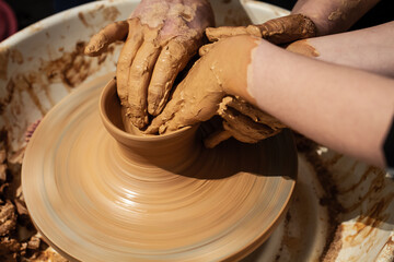 Expert potter teach a child to work on potter wheel