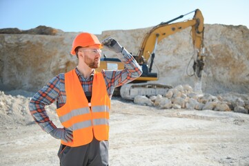 Extraction of stone. Male worker next to stone quarry. Engineer at construction site