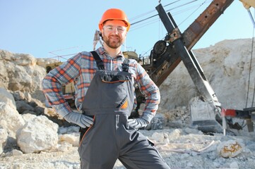 Extraction of stone. Male worker next to stone quarry. Engineer at construction site