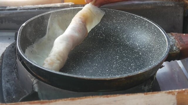 The process of cooking the Indonesian specialty papeda on a Teflon pan, sago dough is cooked until it thickens with a chewy, translucent texture. Cooking Papuan specialty