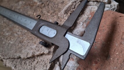 Close-up of a Vernier Caliper Measuring a Brick