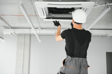 technician cleans air conditioner system in a modern apartment