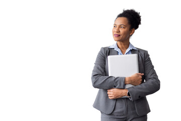 Professional businesswoman wearing gray suit, standing confidently with laptop, looking upward, displaying corporate success