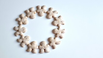 Christmas gingerbread wreath on a white background. Wreath of gingerbread men for a card or background.