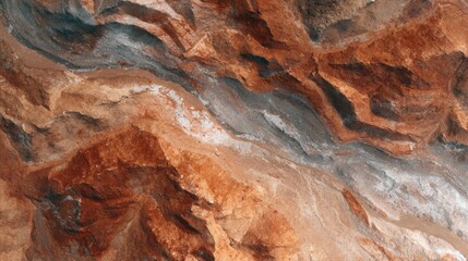 Unique aerial view of colorful rock formations along a winding river under bright sunlight in a remote desert landscape