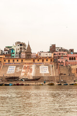 Panoramic view of Jain Ghat in Varanasi featuring colorful buildings and boats on the Ganges River