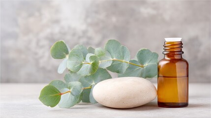 Eucalyptus leaves beside a smooth stone and amber glass bottle on a neutral background, showcasing natural wellness and relaxation concepts in a serene setting