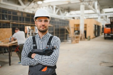 Worker carpenter assembling a modular house