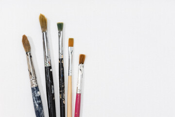Obraz premium Group of paintbrushes on white canvas background. Copy space