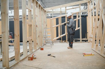 Worker carpenter assembling a modular house