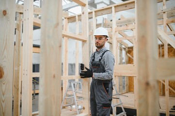Process of construction new and modern modular house. Worker man in special protective uniform wear...