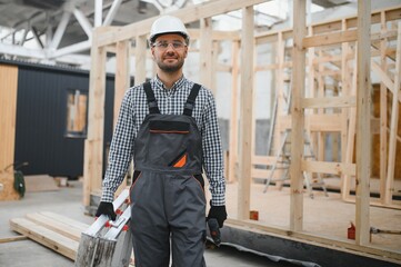 Process of construction new and modern modular house. Worker man in special protective uniform wear...
