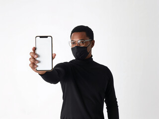 A stylish businessman in a face mask presents his phone's blank screen