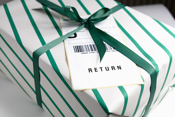 Gift box with return label and decorative green striped wrapping