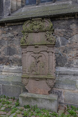 Ancient stone gravestone with moss, historic carved tombstone detail in Hann Munden, Germany