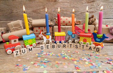 Motiv zum Geburtstag. Ein Holzzug mit Kerzen und Geschenken. 